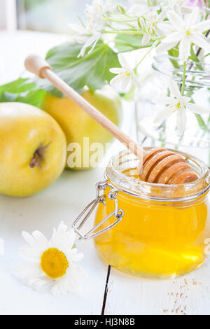 Apple e il miele, cibo tradizionale ebraica di nuovo anno - Rosh Hashana, con fiori di luce sul tavolo di legno Foto Stock