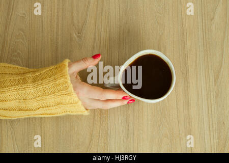 Donna con mano manicure rosso sta per prendere una tazza di caffè Foto Stock