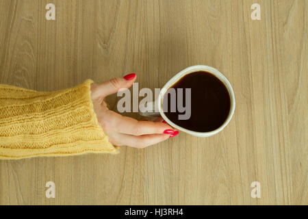 Donna con mano manicure rosso sta per prendere una tazza di caffè Foto Stock