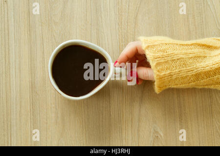 Donna con mano manicure rosso sta per prendere una tazza di caffè Foto Stock