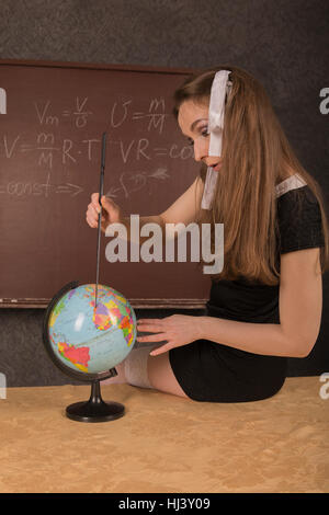 Affascinante ragazza mostra il paese sul globo. Foto Stock