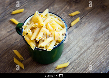 Non cotti materie italiano pasta penne in metallo mug - ingrediente sano per la cottura Foto Stock