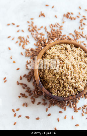 Ciotola di frantumato di semi di lino (massa) di semi di lino bianco sul tavolo di pietra - un sano Organica Vegana Vegetariana ingrediente alimentare Foto Stock