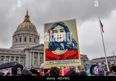 San Francisco, California, Stati Uniti d'America. Il 21 gennaio, 2017. Le donne di marzo - Artista Shepard Fairey il segno "siamo il popolo a difendere la dignità", raffigurante un Latina in rosso, è tenuta in alto in segno di protesta per il rally prima di San Francisco Womens Marzo con City Hall in background. Credito: Shelly Rivoli/Alamy Live News Foto Stock