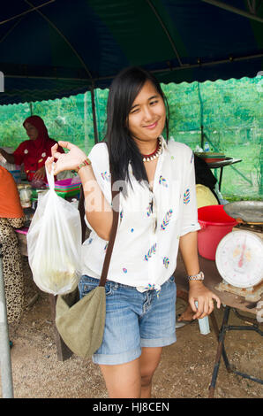 Traveler donna asiatica la felicità e il sorriso dopo l acquisto di frutta Durian da thai fornitori musulmana in strada locale mercato a Koh Yao Noi il 6 giugno 2016 in P Foto Stock