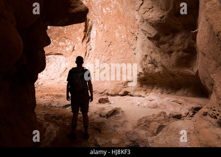 Un escursionista in piedi alla bocca del Cool Grotta lungo il sentiero panoramico. Kodachrome Basin Parco Statale, Utah Foto Stock