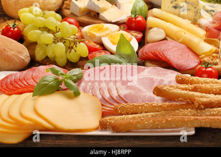 Buffet di vari tipi di formaggi e antipasti impostato su rustiche di legno Foto Stock