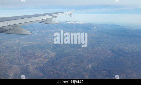 Sierra Nevada e il Monte Mulhacen in Andalusia, Spagna. Vista aerea raffigurato dall'aeromobile. La Sierra Nevada è la montagne coperte di neve in lontananza. Le grandi città direttamente sotto l'ala sul piede delle montagne è Granada. Montare Mulhacen (3,478 metri) è la montagna più alta in Spagna continentale e nella penisola iberica. Foto Stock