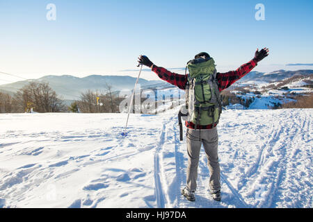 Uomo che passeggia sulla cima della montagna innevata Foto Stock