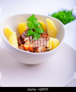 Spezzatino di manzo in uno slow cooker, guarnita con patate e carote. Foto Stock