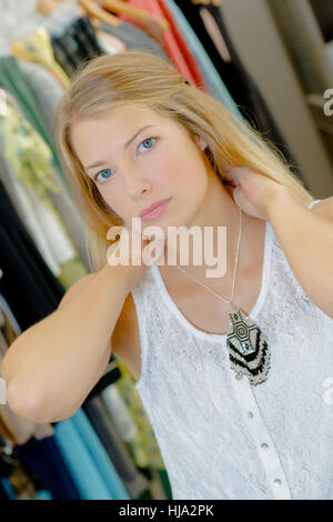 Signora cercando su collana in negozio Foto Stock