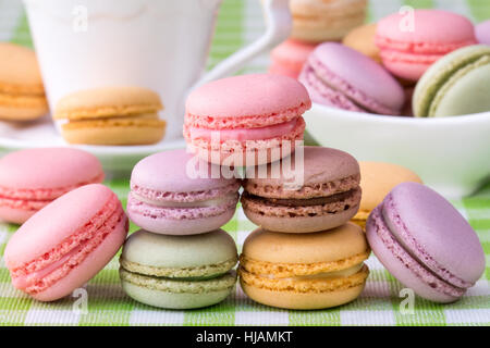 Deliziosi amaretti francese con la tazza di caffè sullo sfondo Foto Stock