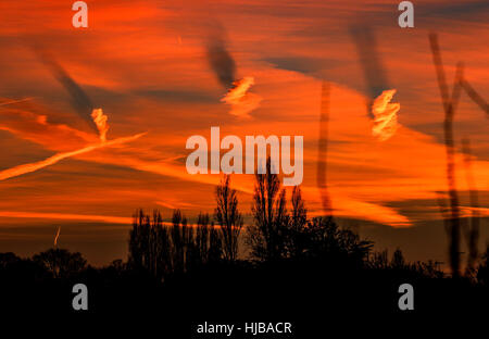 Una forma a spirale nuvole causando ombre su altre nubi in alba rossa Foto Stock