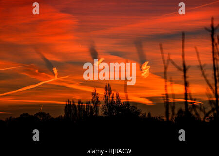 Una forma a spirale nuvole causando ombre su altre nubi in alba rossa Foto Stock