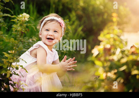 Splendida bambina all'aperto in giardino verde avente un sacco di divertimento Foto Stock