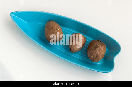 Tre semi di Avocado servito in una piastra di colore blu Foto Stock