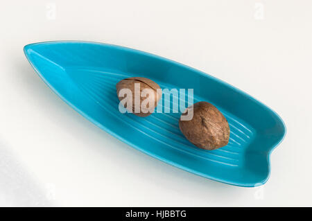 Due semi di Avocado servito in una piastra di colore blu Foto Stock