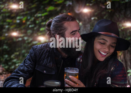 Coppia giovane ridendo nel giardino della birra in serata, Brooklyn, New York, Stati Uniti d'America Foto Stock