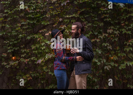 Coppia giovane ridendo nel giardino della birra in serata, Brooklyn, New York, Stati Uniti d'America Foto Stock