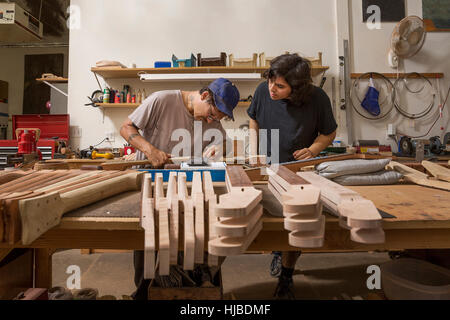 Guitar maker in laboratorio controllo qualità colli di chitarra Foto Stock