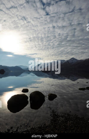 Montagne di rocce e alberi riflessa nella calma superficie di Derwent Water, Keswick, Cumbria, Lake District, England Regno Unito Foto Stock