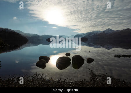 Montagne di rocce e alberi riflessa nella calma superficie di Derwent Water, Keswick, Cumbria, Lake District, England Regno Unito Foto Stock