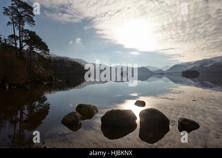 Montagne di rocce e alberi riflessa nella calma superficie di Derwent Water, Keswick, Cumbria, Lake District, England Regno Unito Foto Stock