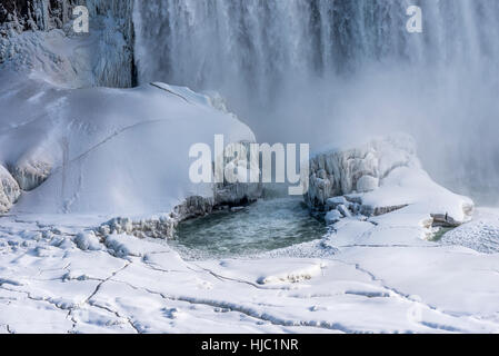 Cascate del Niagara scorre dietro la coperta di neve formazioni di ghiaccio. Foto Stock