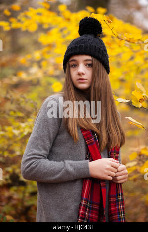 Bella ragazza adolescente indossando cappello di lana con colori autunnali in background Foto Stock