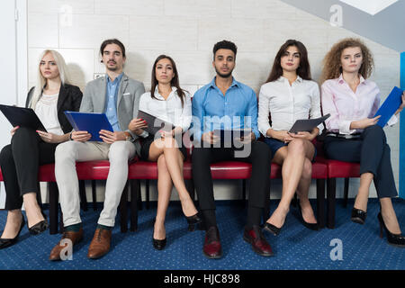 Stanco candidati attendere per il colloquio di lavoro, Mix gara Business persone sedute in linea le risorse umane Foto Stock