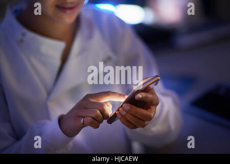 Scienziato in laboratorio scrivere messaggi sullo smartphone Foto Stock