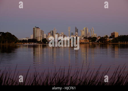 Vista da Burswood attraverso il Fiume Swan e dello skyline di Perth compresi al WACA Stadium, nel bellissimo pre-luce di alba Foto Stock