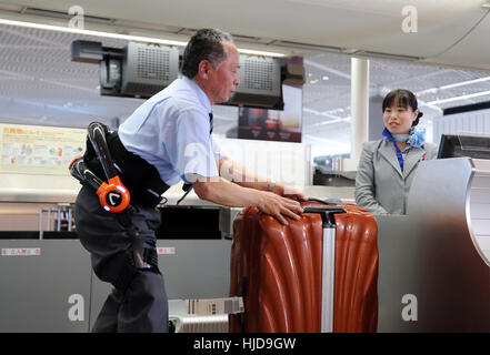 Narita, Giappone. 24 gen 2017. All Nippon Airways (ANA) personale di terra che indossa una tuta robot ibrido arto Assistive (HAL), sviluppato da Tsukuba University Professor Yoshiyuki Sankai e Cyberdyne dimostra per il trasporto di un bagaglio pesante all'ANA al banco check-in quanto le compagnie aeree hanno iniziato le loro prove in campo di HAL all'Aeroporto Internazionale di Narita a Narita, suburbana Tokyo Martedì, 24 gennaio 2017. Credito: Aflo Co. Ltd./Alamy Live News Foto Stock