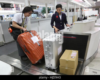 Narita, Giappone. 24 gen 2017. Japan Airlines (JAL) personale di terra che indossa una tuta robot ibrido arto Assistive (HAL), sviluppato da Tsukuba University Professor Yoshiyuki Sankai e Cyberdyne dimostra per il trasporto di un bagaglio pesante alla JAL al banco check-in quanto le compagnie aeree hanno iniziato le loro prove in campo di HAL all'Aeroporto Internazionale di Narita a Narita, suburbana Tokyo Martedì, 24 gennaio 2017. Credito: Aflo Co. Ltd./Alamy Live News Foto Stock