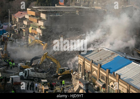 Tehran, Iran. 23 gen 2017. Soccorritori alla ricerca di vittime del crollo è il sito di un edificio commerciale a Teheran, capitale dell'Iran, 23 gennaio, 2017. Almeno 30 persone sono state uccise nel crollo di un 17 piani di giovedì scorso, premere TV segnalati. Credito: Ahmad Halabisaz/Xinhua/Alamy Live News Foto Stock