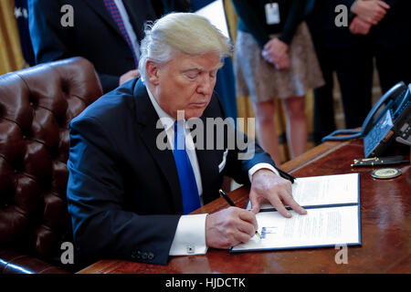 Washington, Stati Uniti d'America. 24 gen 2017. Il presidente statunitense Donald Trump segni uno dei cinque ordini esecutivi relativi all'olio industria pipeline nell'ufficio ovale della Casa Bianca di Washington, DC, Stati Uniti d'America. Credito: Shawn Thew/Piscina via CNP /MediaPunch Inc/Alamy Live News Foto Stock