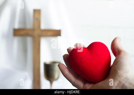 Dando il cuore a Gesù concetto astratto con croce di pasqua su sfondo bianco Foto Stock