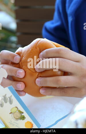 Un bambino mangiare Australian McDonald's Filet-o-hamburger di pesce Foto Stock