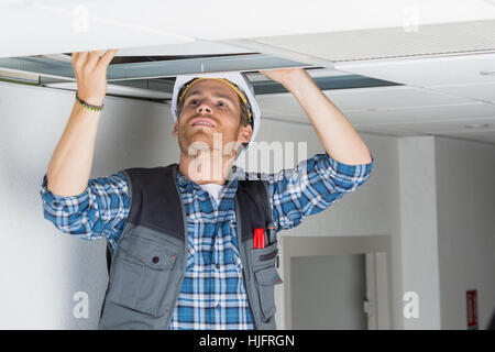 Elettriche Cablaggio lavoratore nel soffitto Foto Stock