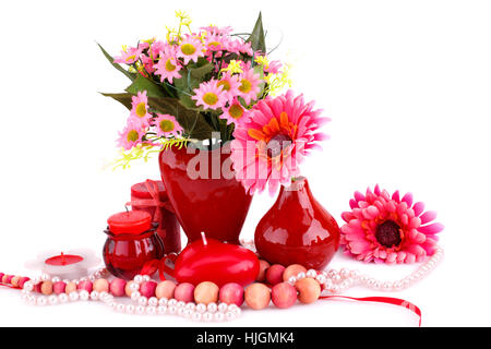 Fiori colorati, vasi, candele e collane su sfondo bianco. Foto Stock