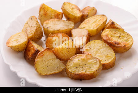 Close up di patate al forno cunei su piastra bianca Foto Stock