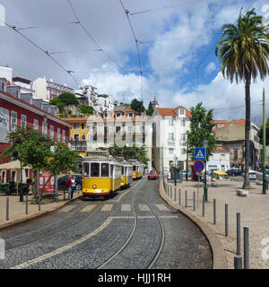 Tram giallo su una strada acciottolata a Lisbona, Portogallo Foto Stock