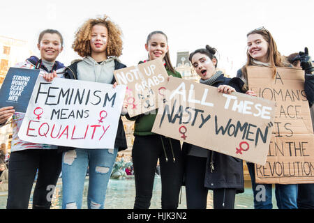 Un gruppo di giovani donne Mostra intestazioni in anti - Trump marzo a Trafalgar Square a Londra. Foto Stock