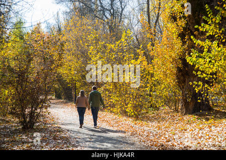 Coppia matura a piedi lungo un sentiero nella foresta di autunno. Sierra de Guadarrama National Park, Rascafria, provincia di Madrid, Spagna. Foto Stock