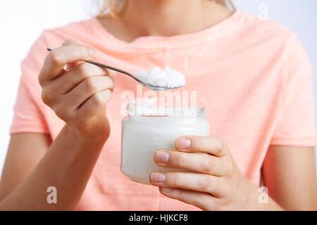 Close Up di donna con 1 cucchiaio di olio di noce di cocco Foto Stock