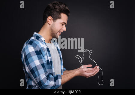 Bel giovane tenendo un gattino. Foto Stock