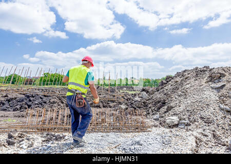 Vista sul team di costruzione i lavoratori che vengono trasferiti di recente costruzione telaio basamento sul sito. Foto Stock