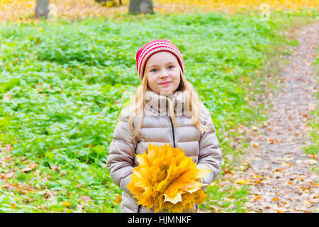 Foto della ragazza con bouquet da fogli in autunno Foto Stock