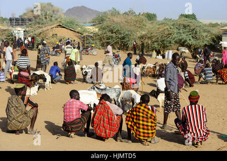 KENIA Turkana, Lodwar, mercato del bestiame, herder compra e vende capre, uomo seduto sul loro piccole sedie di legno / Turkana mit Ziegen auf dem Viehmarkt, Turkana Maenner sitzen auf kleinen Holz Hockern Foto Stock