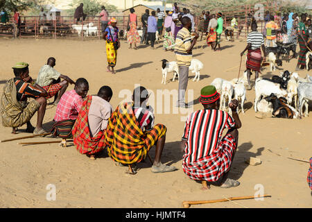 KENIA Turkana, Lodwar, mercato del bestiame, herder compra e vende capre, uomo seduto sul loro piccole sedie di legno / Turkana mit Ziegen auf dem Viehmarkt, Turkana Maenner sitzen auf kleinen Holz Hockern Foto Stock